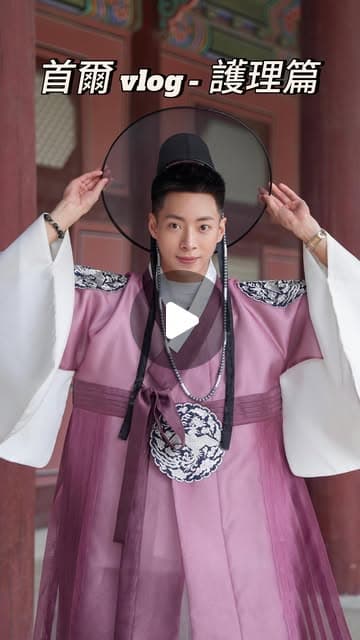 Samson Lam 穿著粉紫色韓服、戴著黑色笠帽，在古宮建築前雙手扶帽擺姿勢，上方寫著「首爾 vlog - 護理篇」